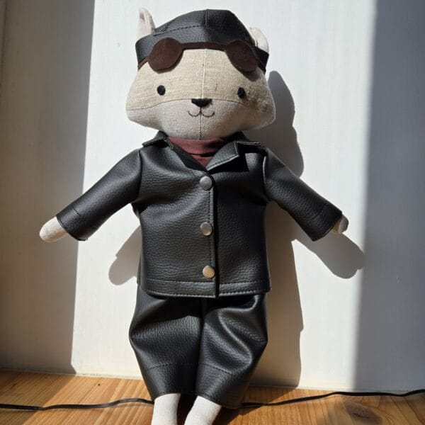 peluche loup motard habillé de cuir avec ses lunettes de soleil et son couvre chef noir.